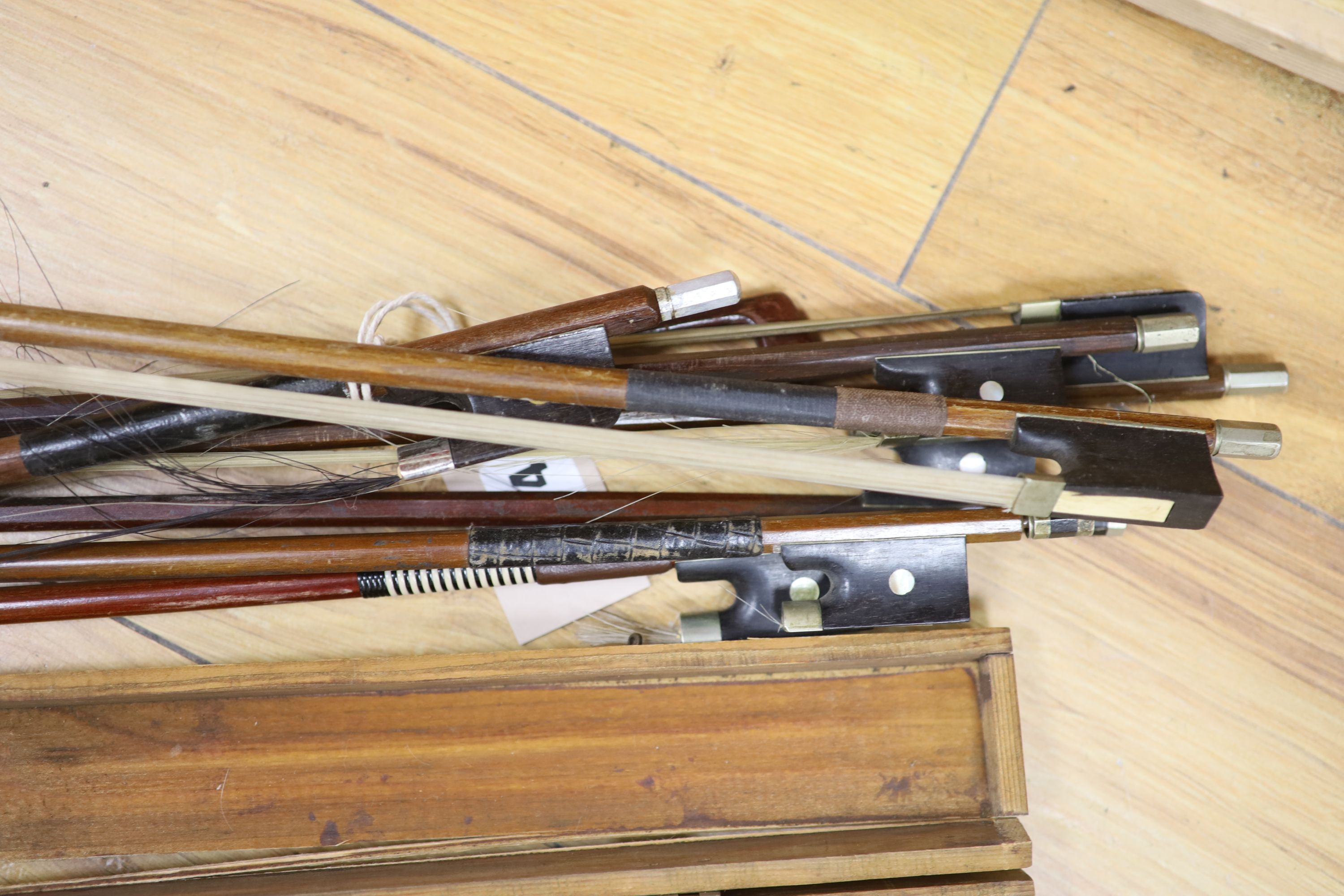 A quantity of violin bows and box, together with a print